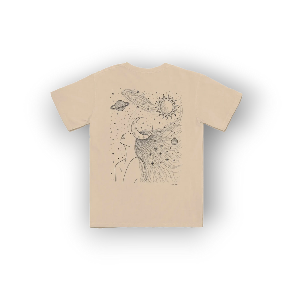 A beige short-sleeve t-shirt with a black line art graphic of a woman's profile with celestial elements like a sun, moon, and planets in her hair, shown on a white background.