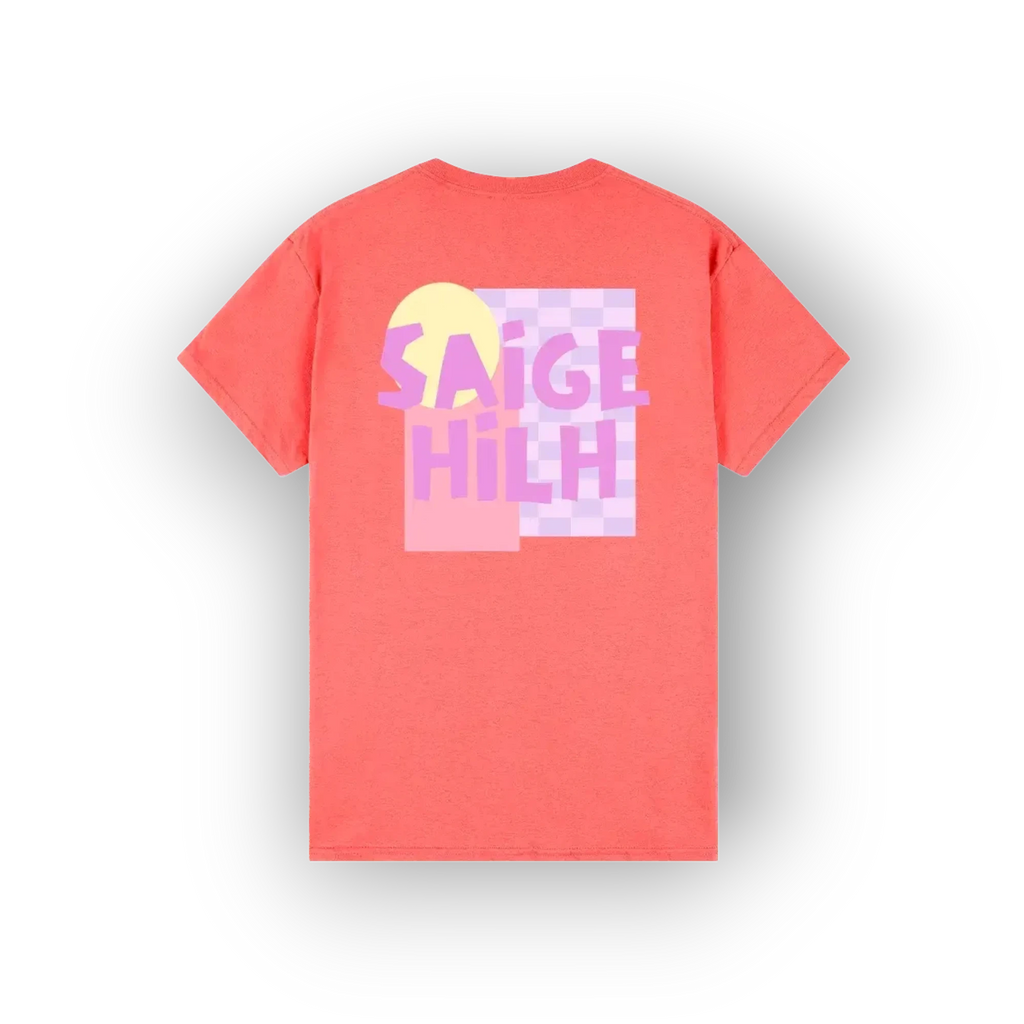 A coral pink short-sleeve t-shirt shown from the back, featuring a colorful graphic print with the text 'SAIGE HILH' in pink and purple over a pastel yellow and purple checkerboard background.