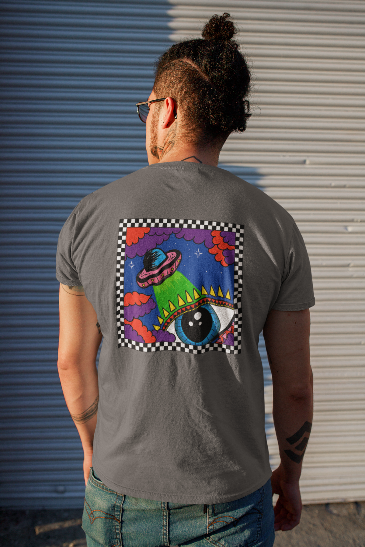 male model with a grey tshirt and a alien and eye art design on the back of the tshirt