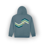 A slate blue hoodie shown from the back, featuring an original artist designed large chevron graphic in shades of teal, green, and white with the text 'SAIGE HILH' printed in yellow.
