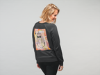 A woman wearing a black sweatshirt with a large back graphic of a queen playing card illustration, shown from behind