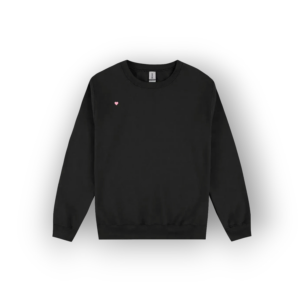 A black crewneck sweatshirt with a small pink heart logo on the left chest, displayed against a clean white background with a soft drop shadow.
