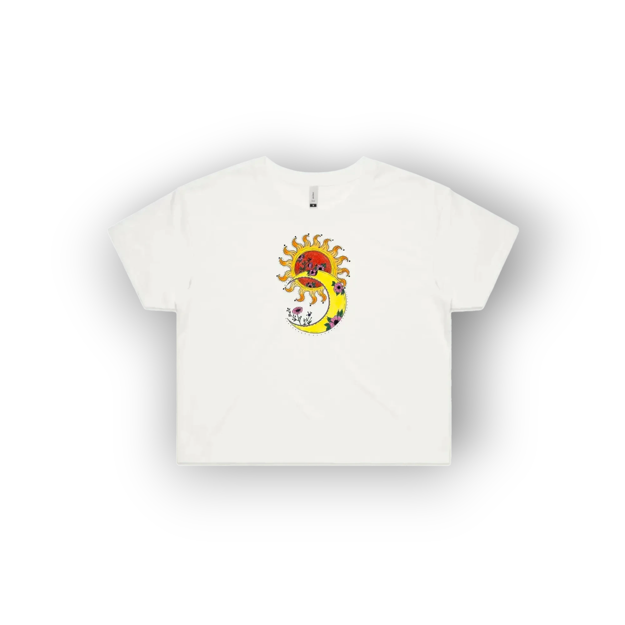 A white short-sleeve crop top t-shirt featuring an original artist designed  colourful graphic print on the chest of a sun, a crescent moon, and a red heart.