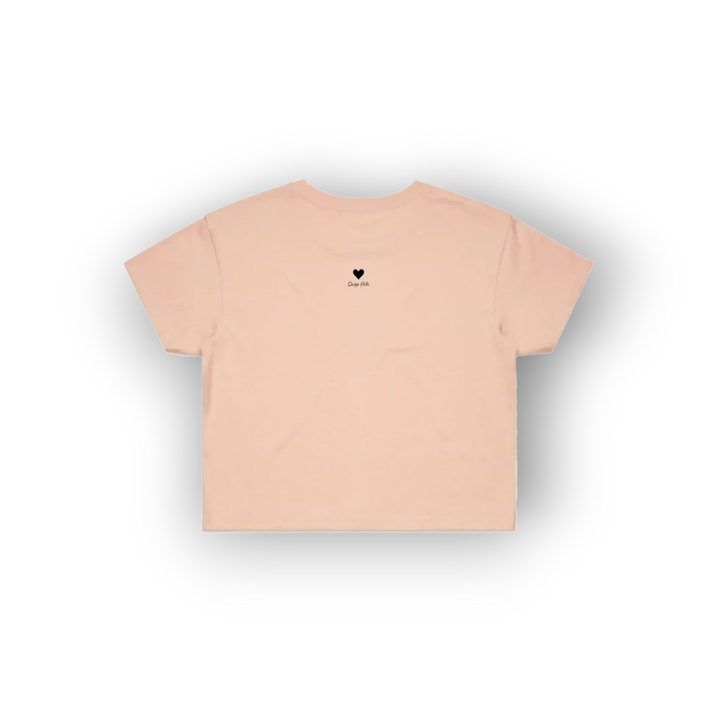 A light peach-pink short-sleeve t-shirt with a small black heart and 'love' text printed on the center chest, displayed against a clean white background.